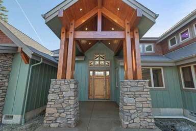 exterior of green custom house with wooden beams  by Corvallis Custom Kitchens & Baths in Corvallis, Oregon 