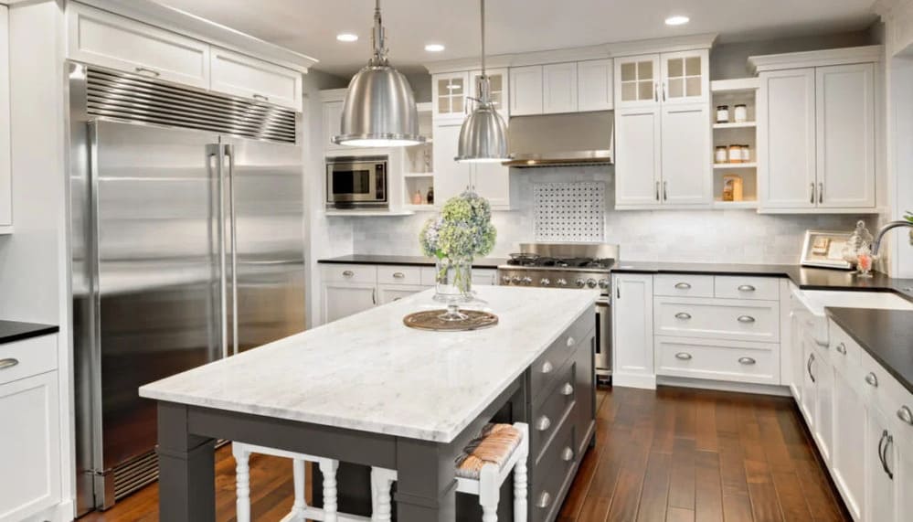 white quartzite kitchen island countertops with dark wood flooring - photo by progressive dimensions