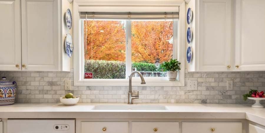 Beautiful remodeled kitchen sink with fall background.