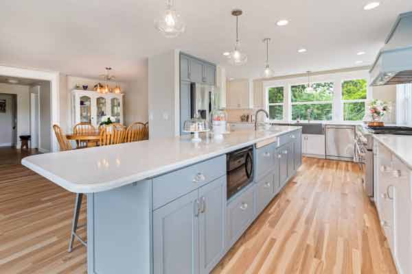 open kitchen with power blue cabinets and wooden floors  by Corvallis Custom Kitchens & Baths in Corvallis, Oregon