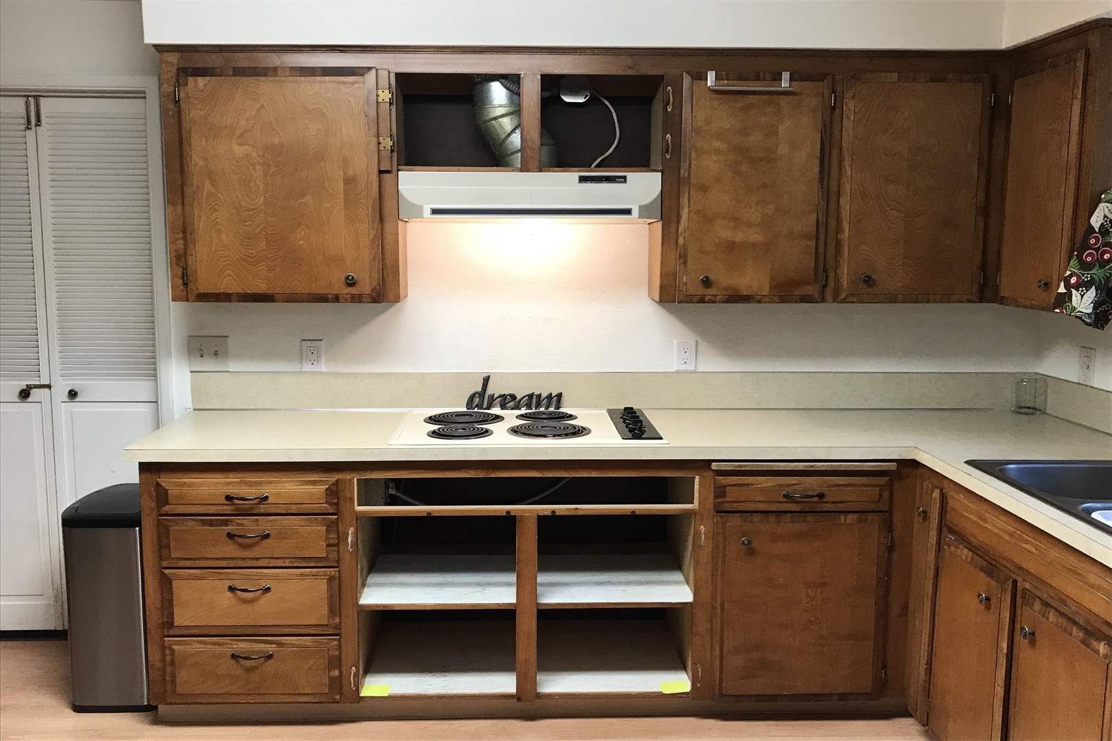 before photo with brown cabinets and missing oven/microwave