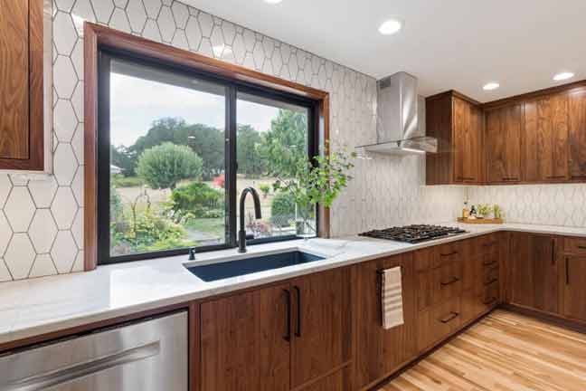 bright kitchen with geometric backsplash and dark wood cabinets by Corvallis Custom Kitchens & Baths in Corvallis, Oregon